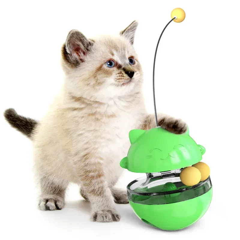 gioco dispenser per gatti verde accanto a un gattino