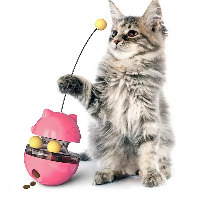 gioco dispenser per gatti rosa che lascia cadere crocchette mentre un gattino gioca